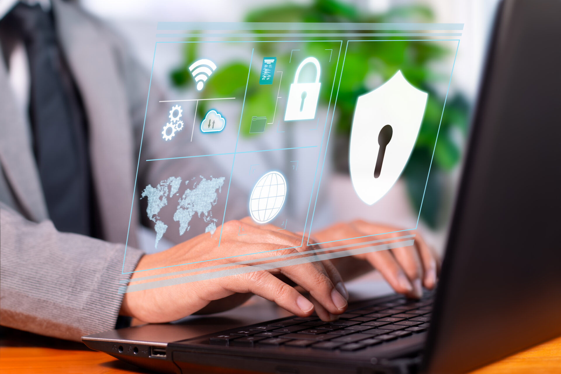 Handen van een persoon in pak typen op een laptop, met zwevende cybersecurity-iconen (slot, schild, wifi, cloud en wereldbol) die gegevensbeveiliging illustreren.